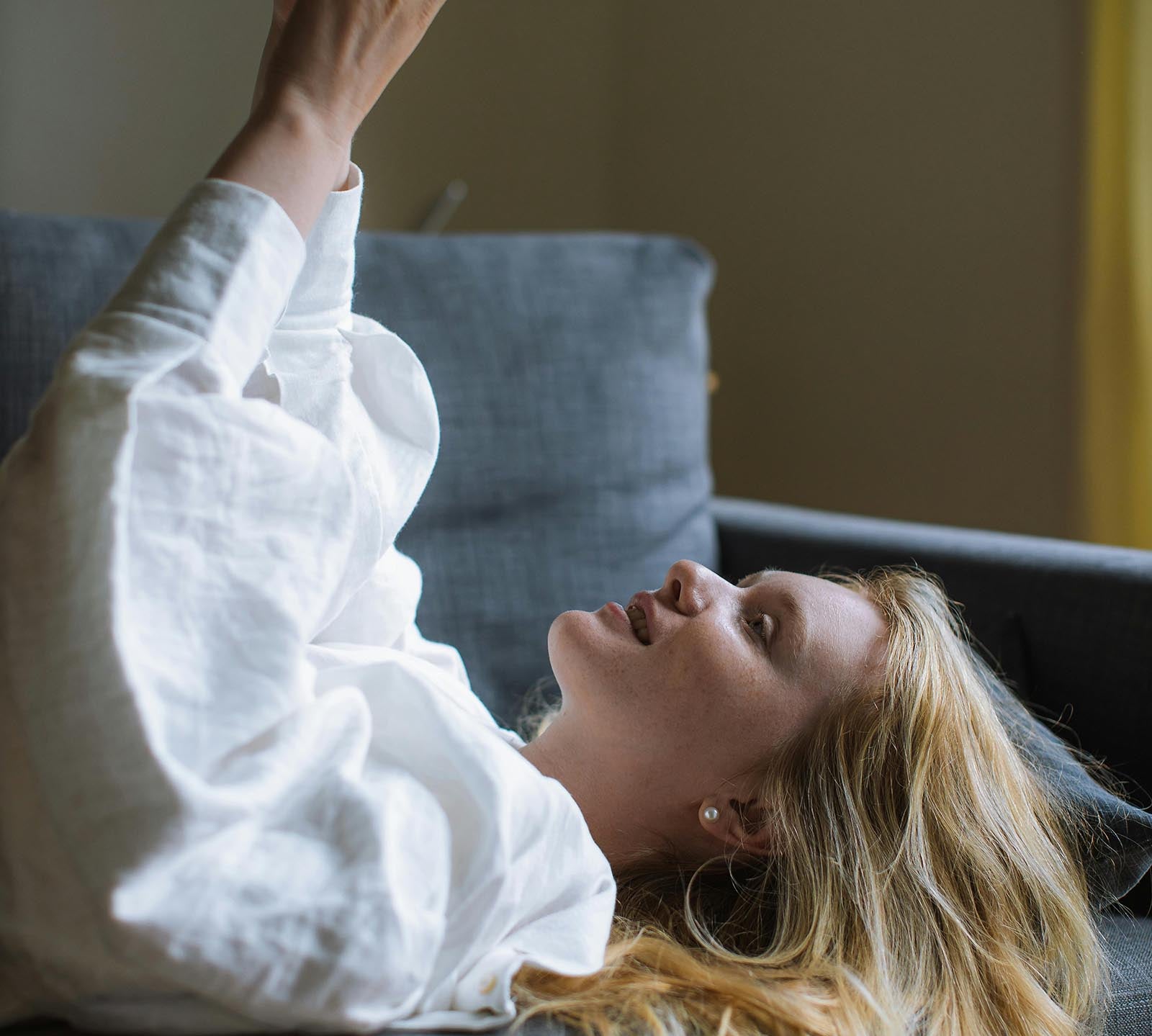 Young woman taking a selfie on the couch