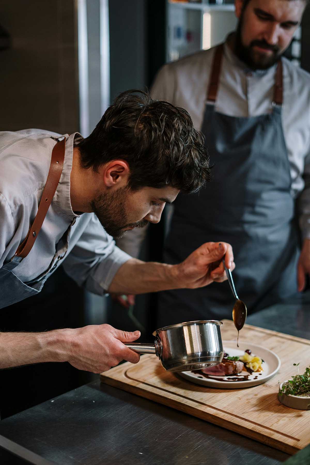 Chef adding a sauce to food in a restaurant