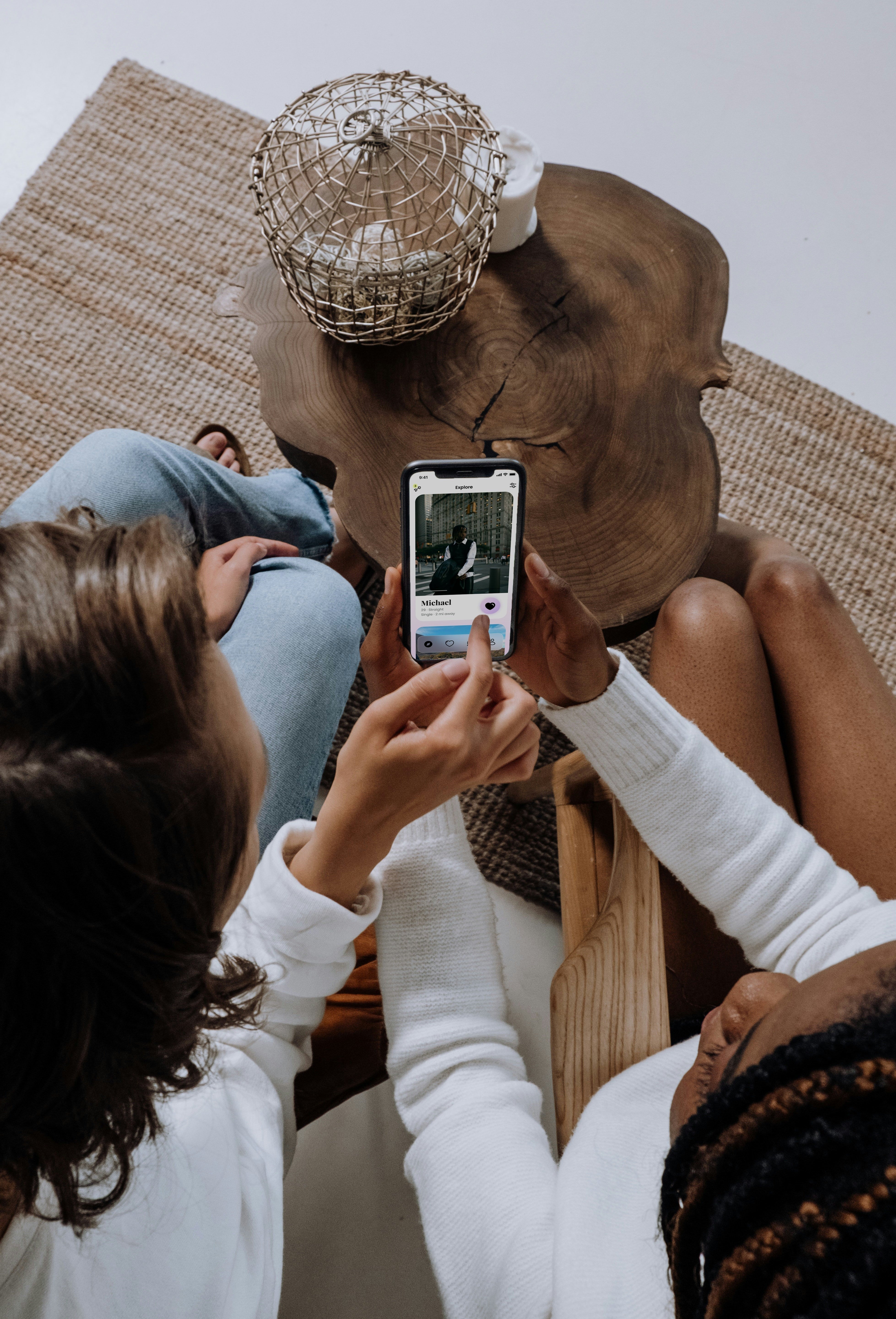 Women reviewing dating profile on phone