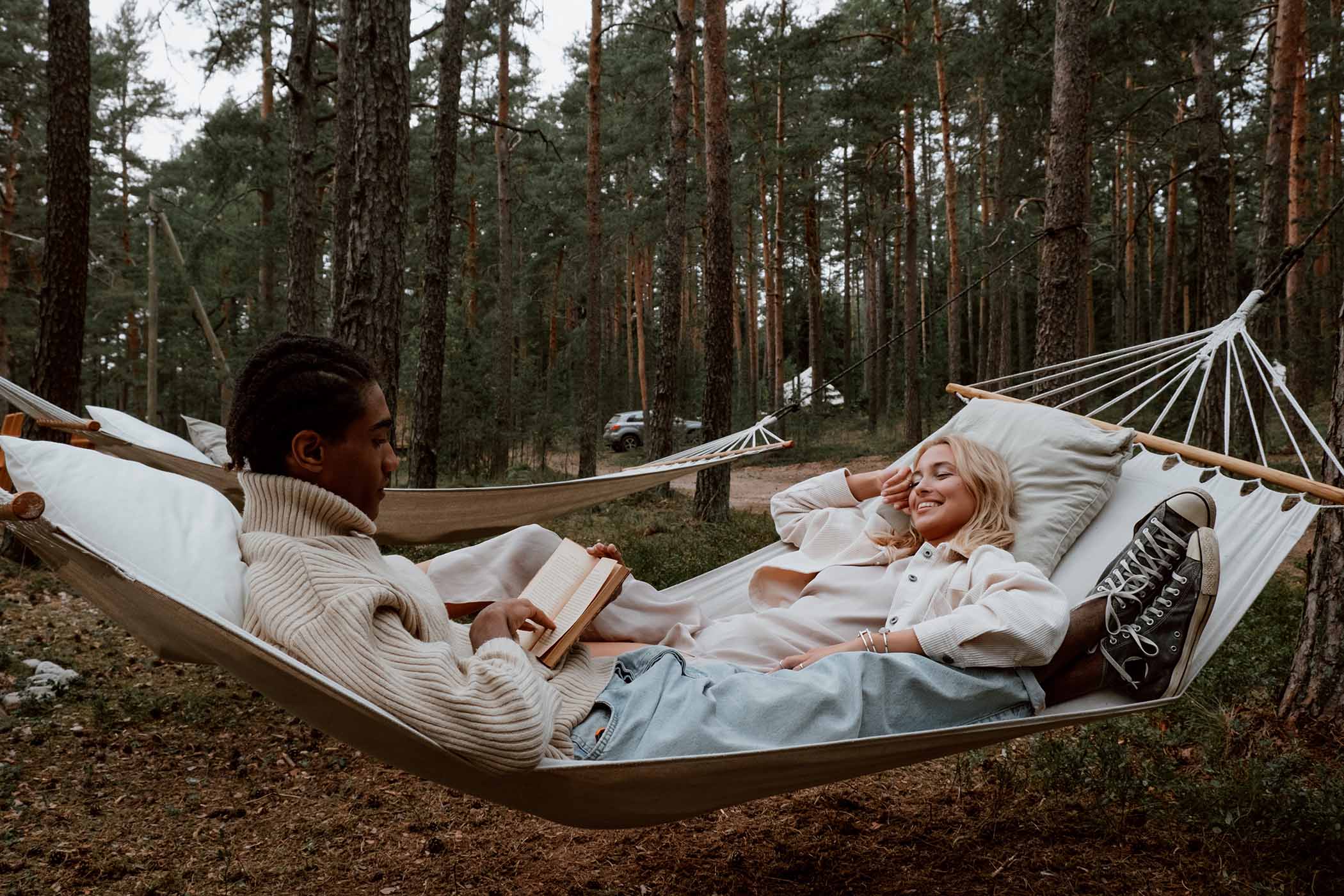 Two people in a hammock in the woods