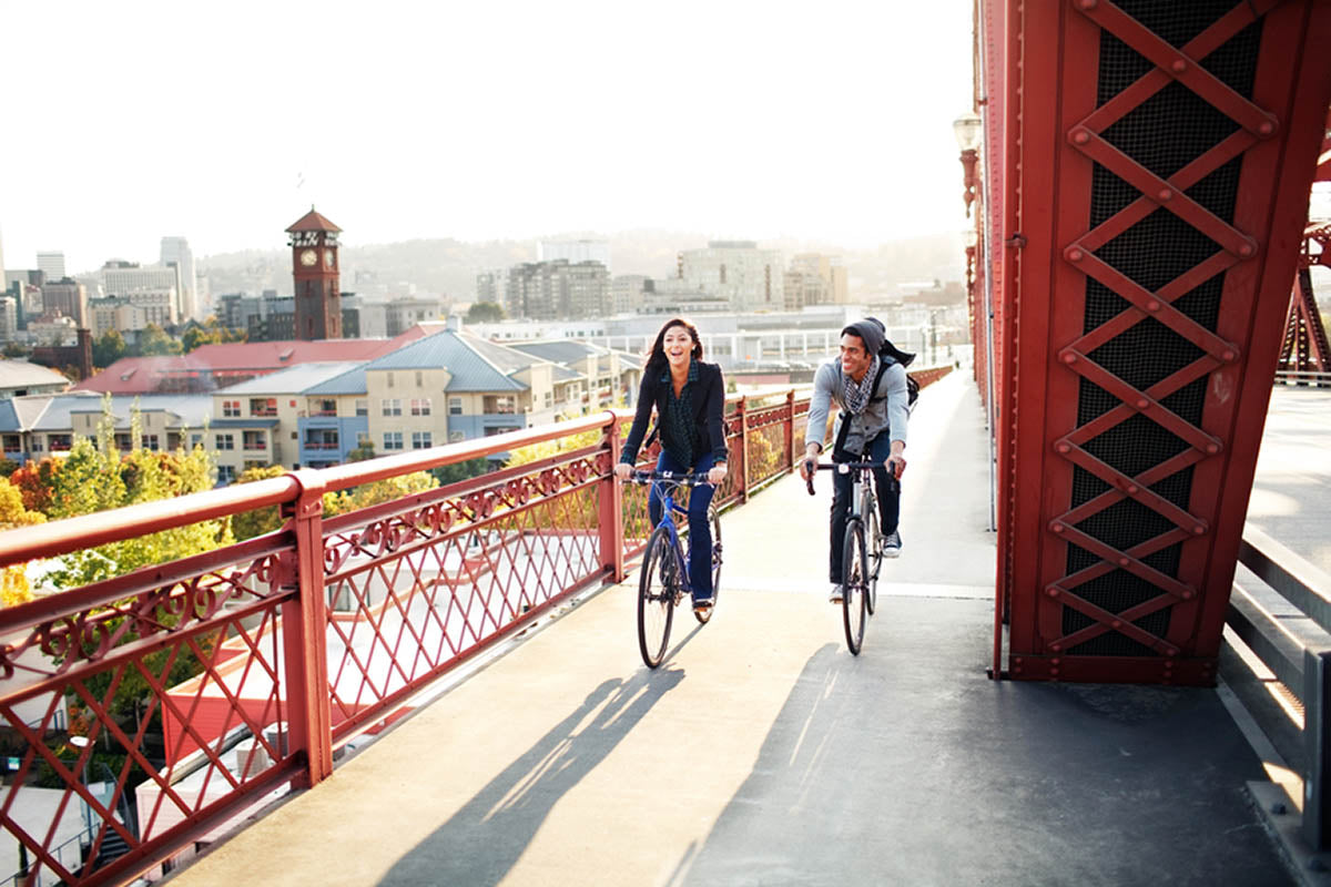 2 women biking across a portland bridge