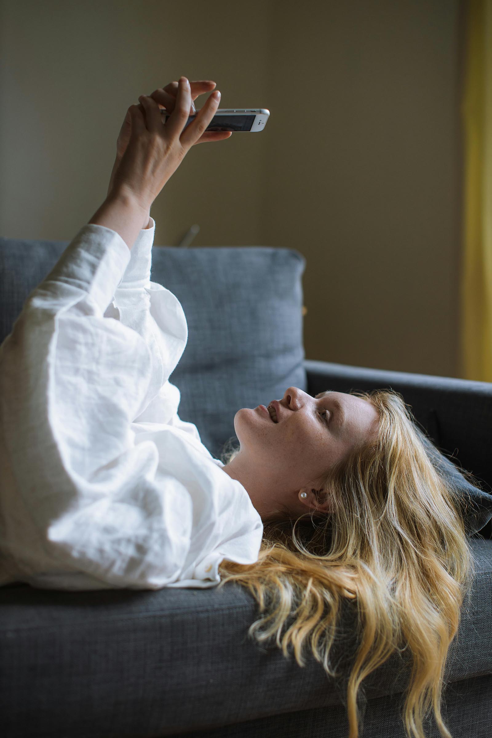 Young woman taking a selfie on the couch