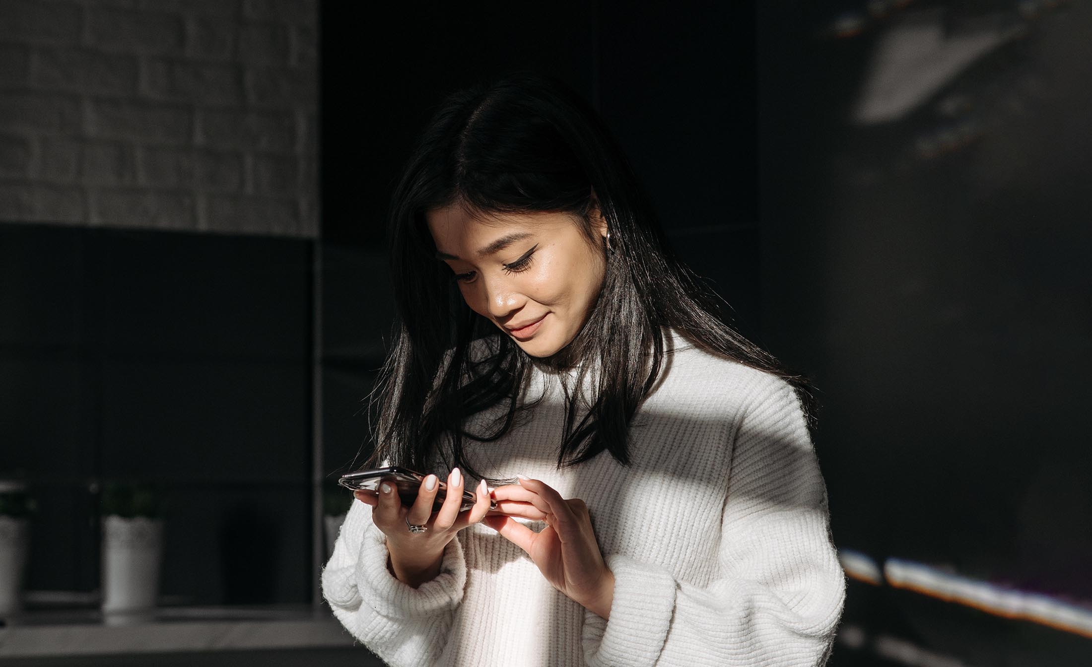 Asian woman looking at an iphone