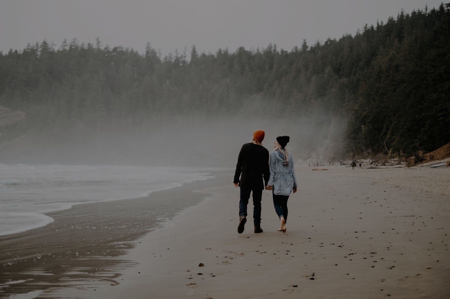 Two people walking on the beach