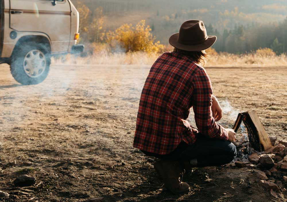 Man at a campfire in front of a van