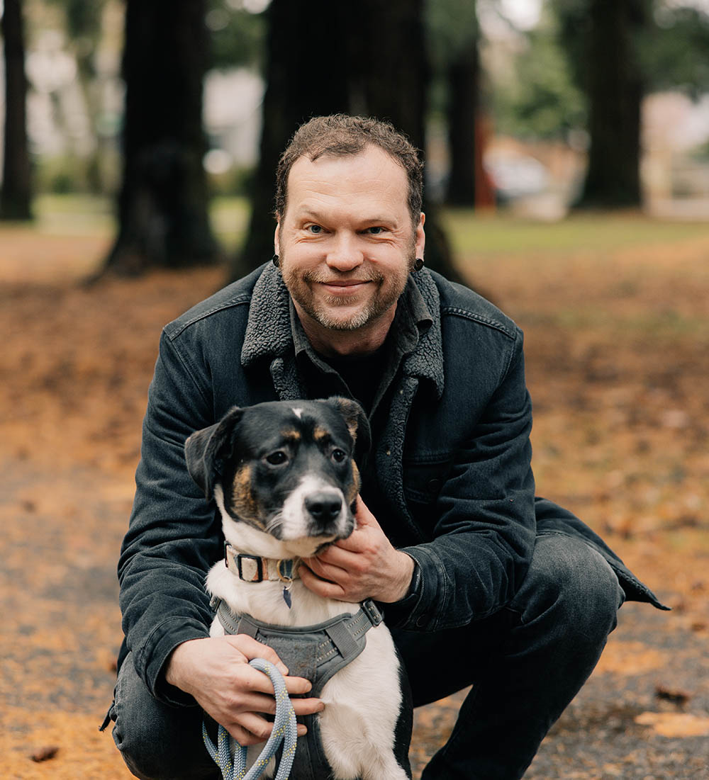 Man holding a dog outside