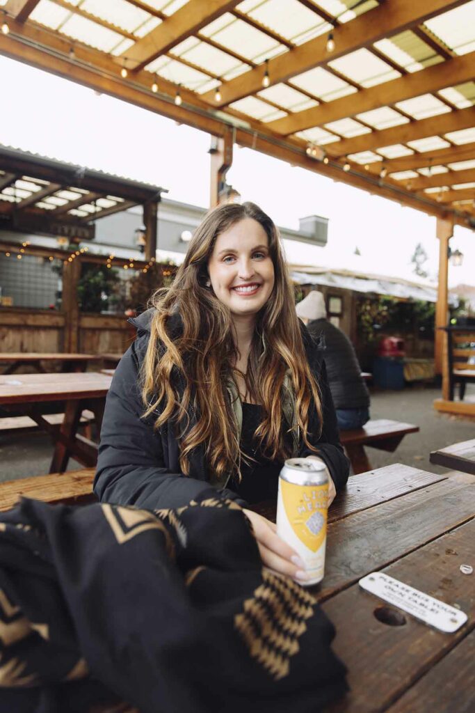 Woman sitting at brewery smiling