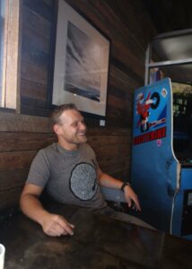man in a pinball arcade