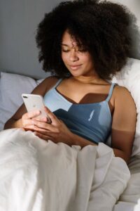 woman in bed looking at an iphone